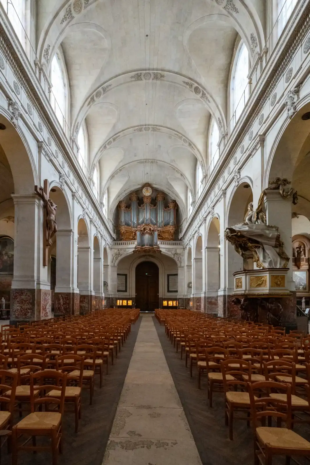 La nef de l'église Saint-Roch présente des rangées de chaises face à un orgue.