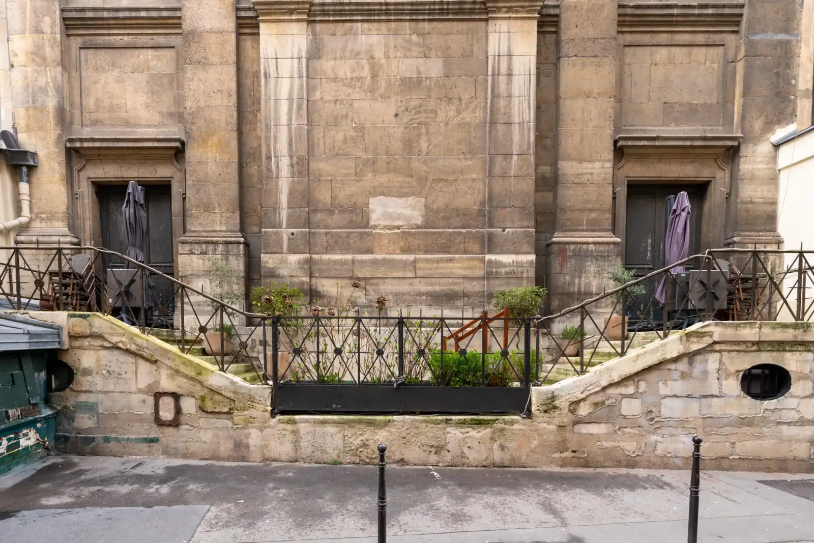 La façade en pierre de l'église Saint-Roch présente un petit jardin avec grille.