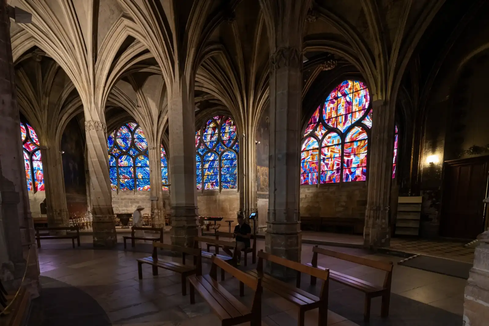 Intérieur de l’église Saint-Séverin à Paris, avec ses voûtes gothiques et ses vitraux colorés.