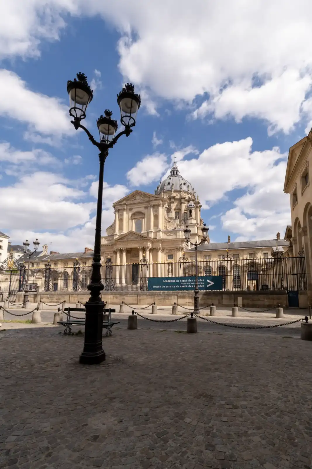 Un candélabre noir se dresse devant la façade de l église du Val de Grâce à Paris.