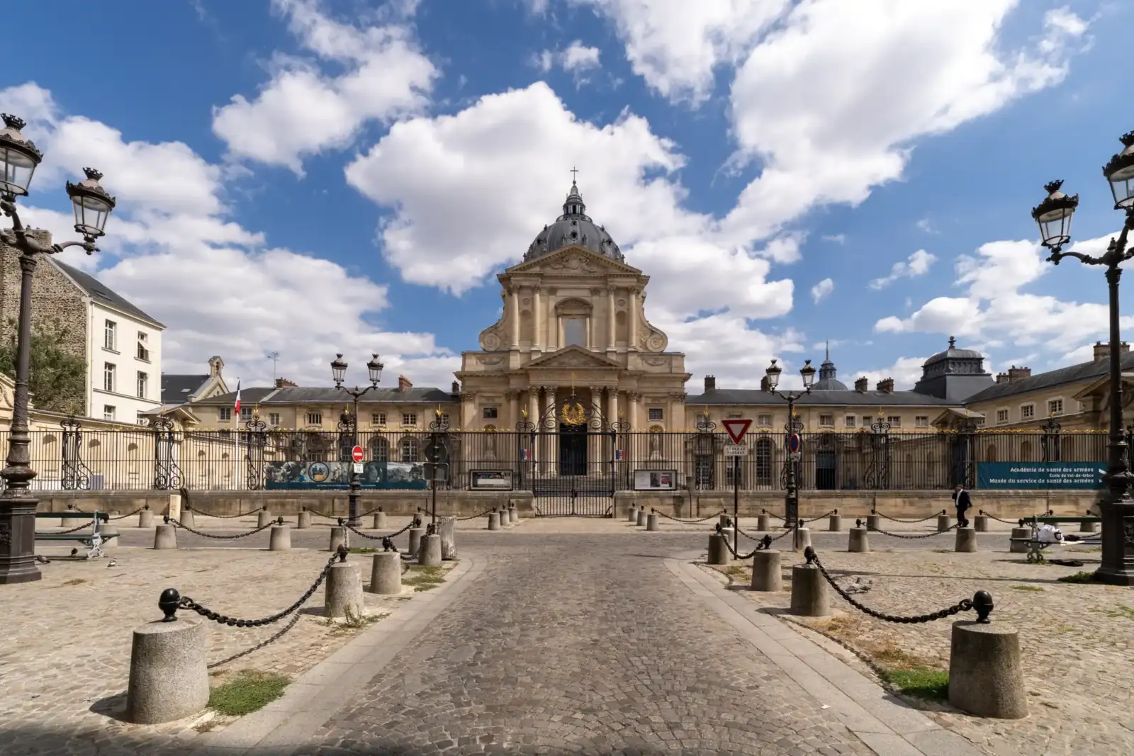 Vue extérieure de l'église du Val-de-Grâce à Paris sous un ciel nuageux.