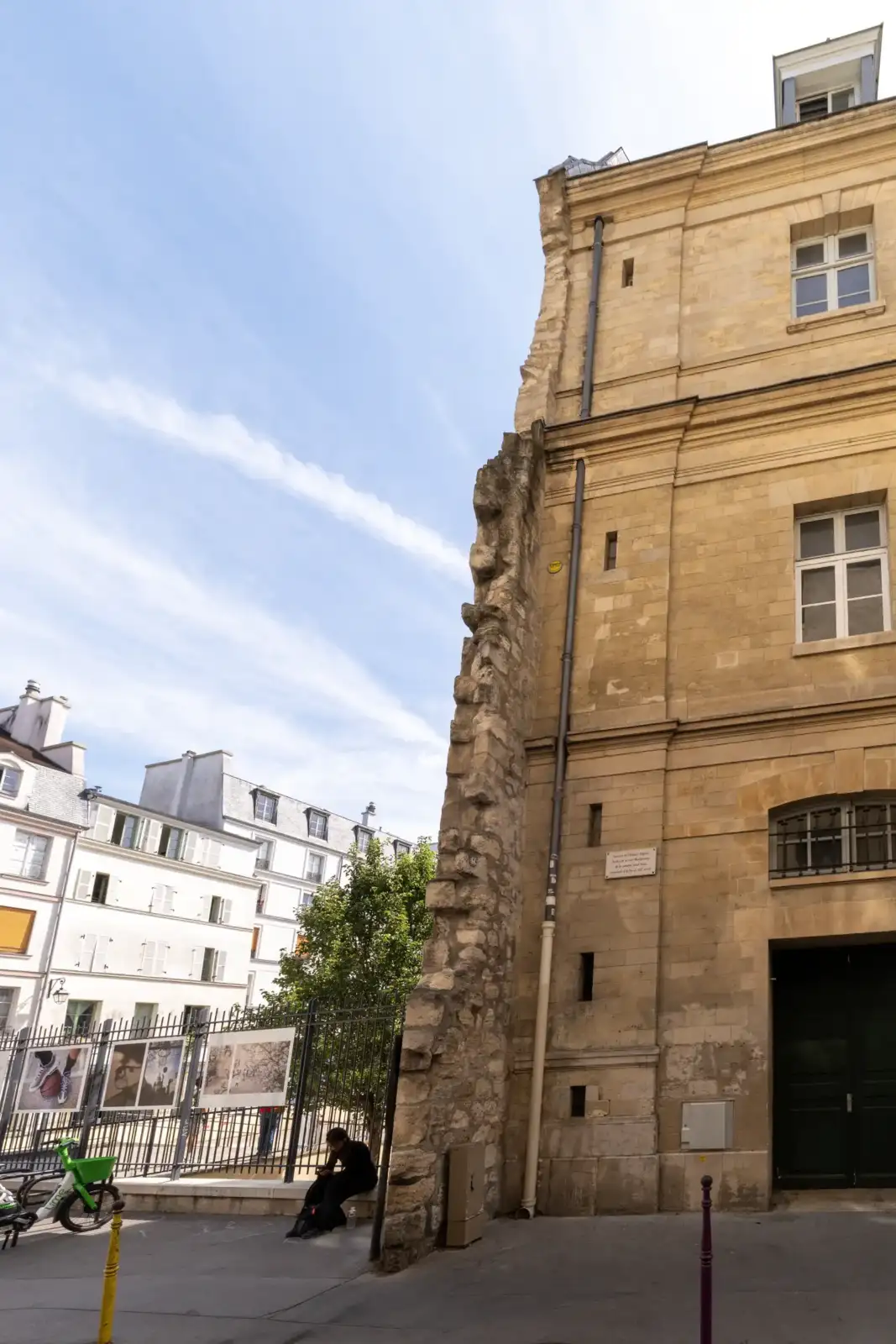 La façade en pierre de l enceinte de Philippe Auguste à Paris sous un ciel bleu.
