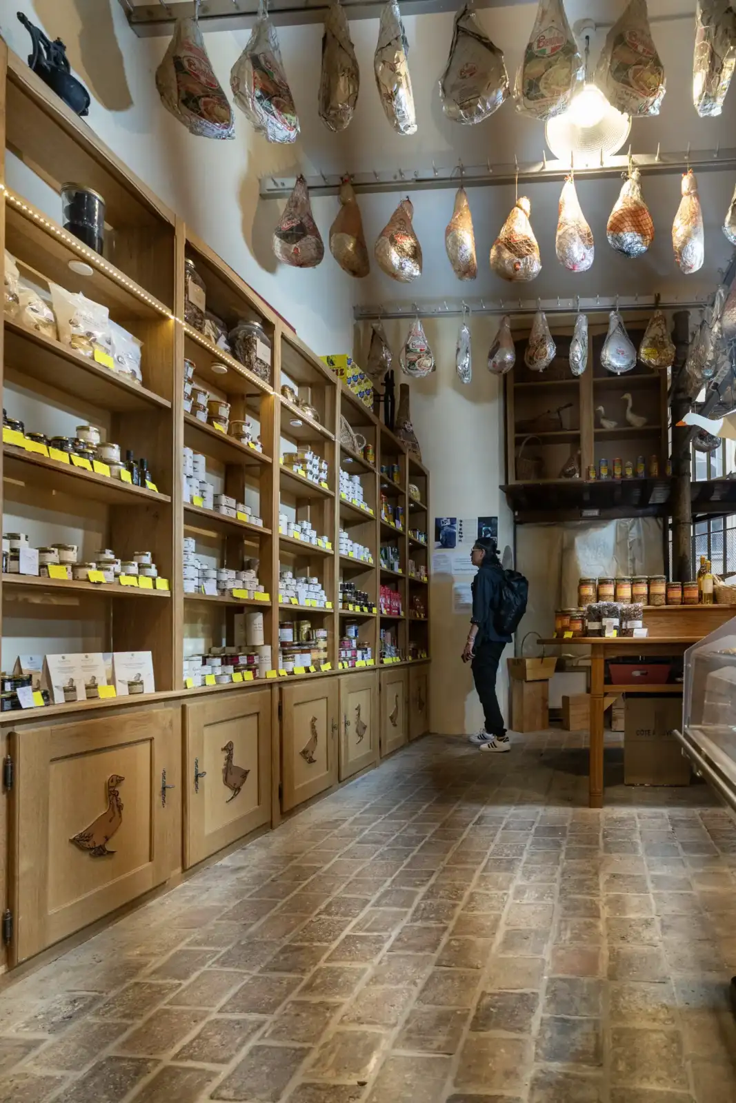 Un client observe des produits de luxe dans une épicerie fine parisienne.