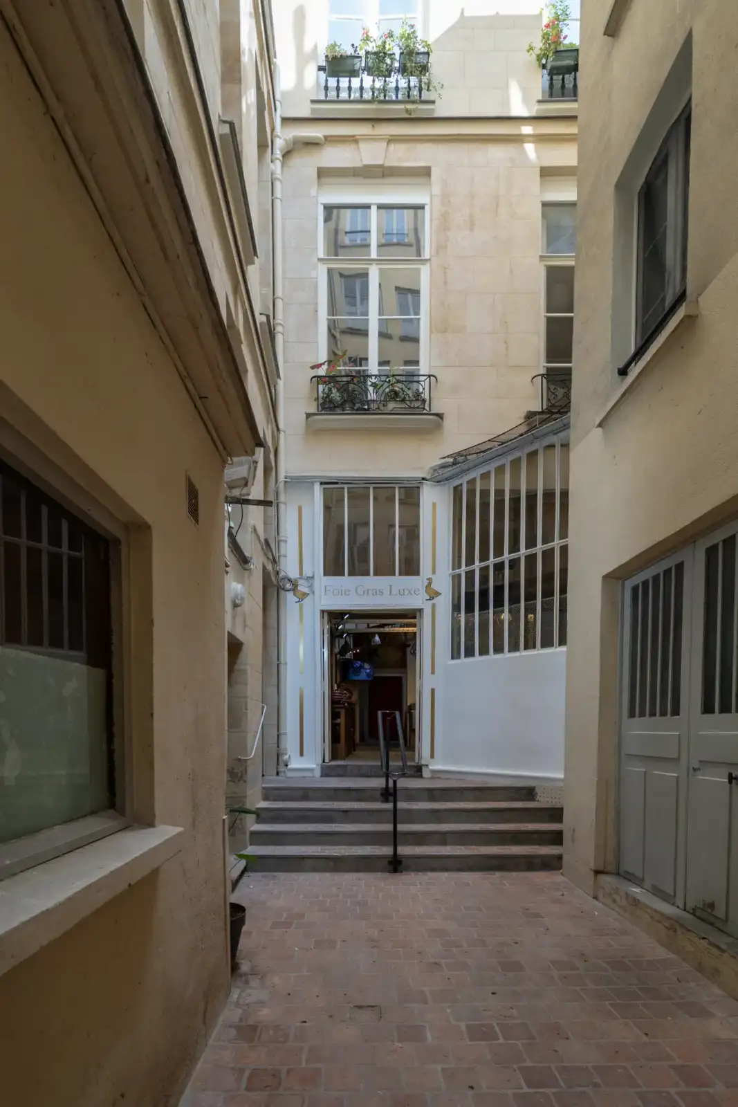 Vue en contre-plongée de la devanture d’une épicerie fine parisienne spécialisée en foie gras.