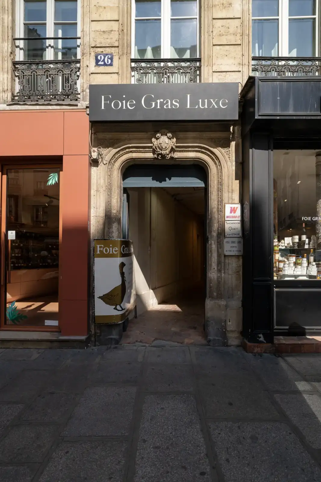 Vue extérieure d'une épicerie de luxe de foie gras à Paris, avec un panneau.