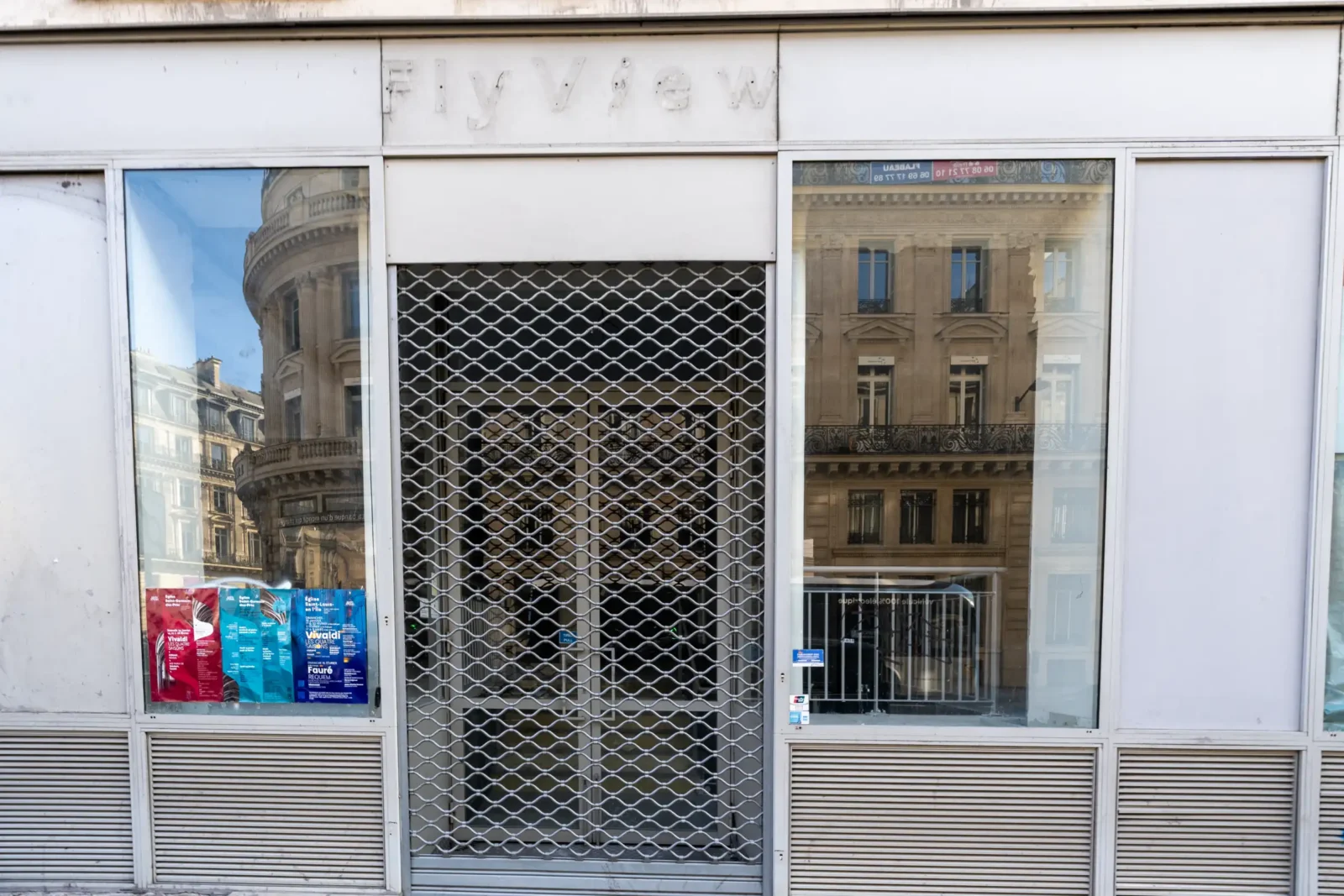 La façade fermée de FlyView à Paris reflète les immeubles haussmanniens environnants en ville.
