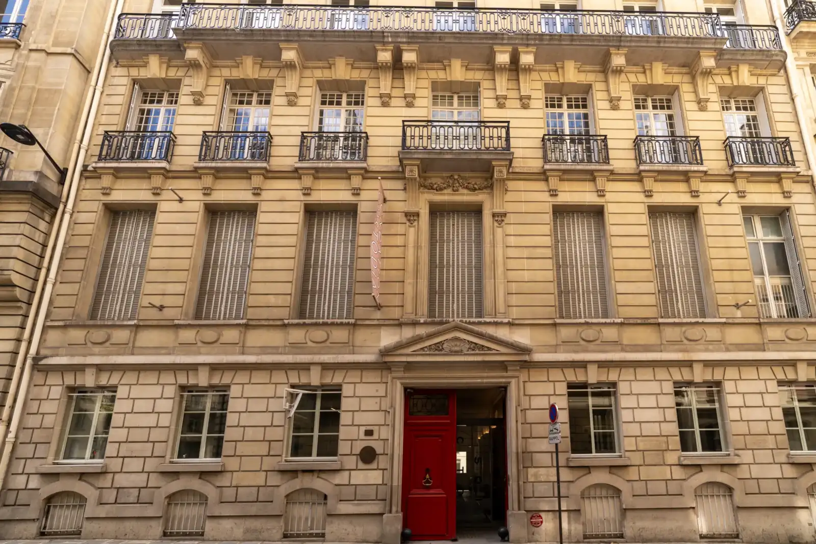 Façade haussmannienne beige de la Fondation Custodia avec une grande porte rouge au rez-de-chaussée.