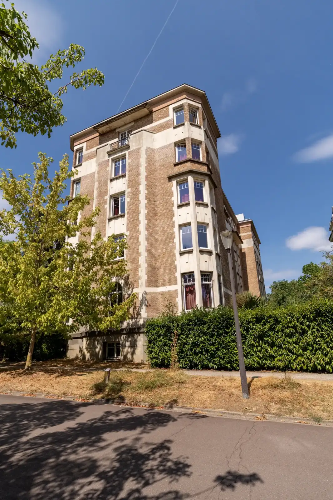 Façade de la Fondation des États-Unis à Paris, bordée d arbres sous un ciel bleu.