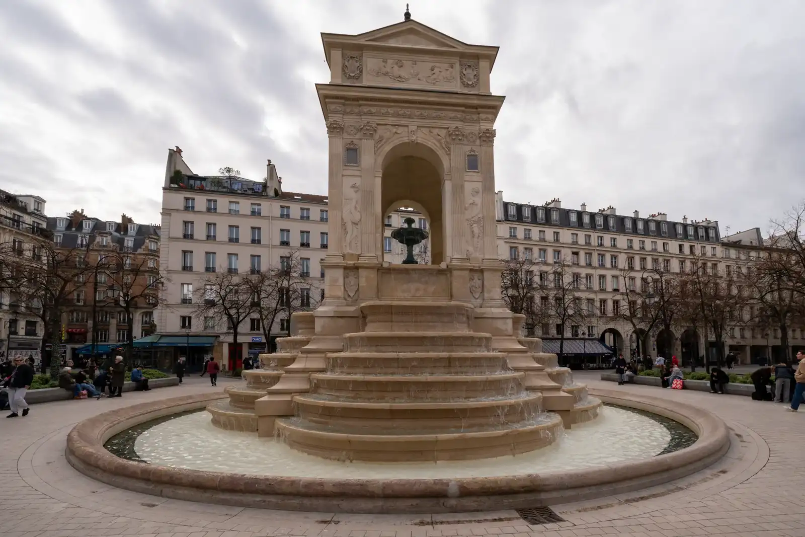 La fontaine des Innocents à Paris se dresse au milieu d'une place urbaine animée.