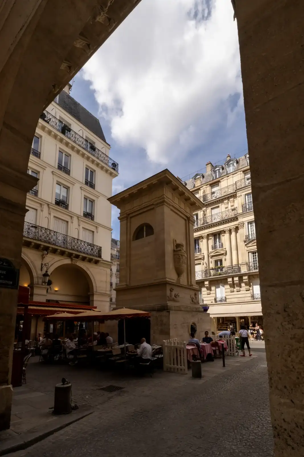 Vue encadrée de la fontaine de Mars à Paris encadrée par des immeubles parisiens.