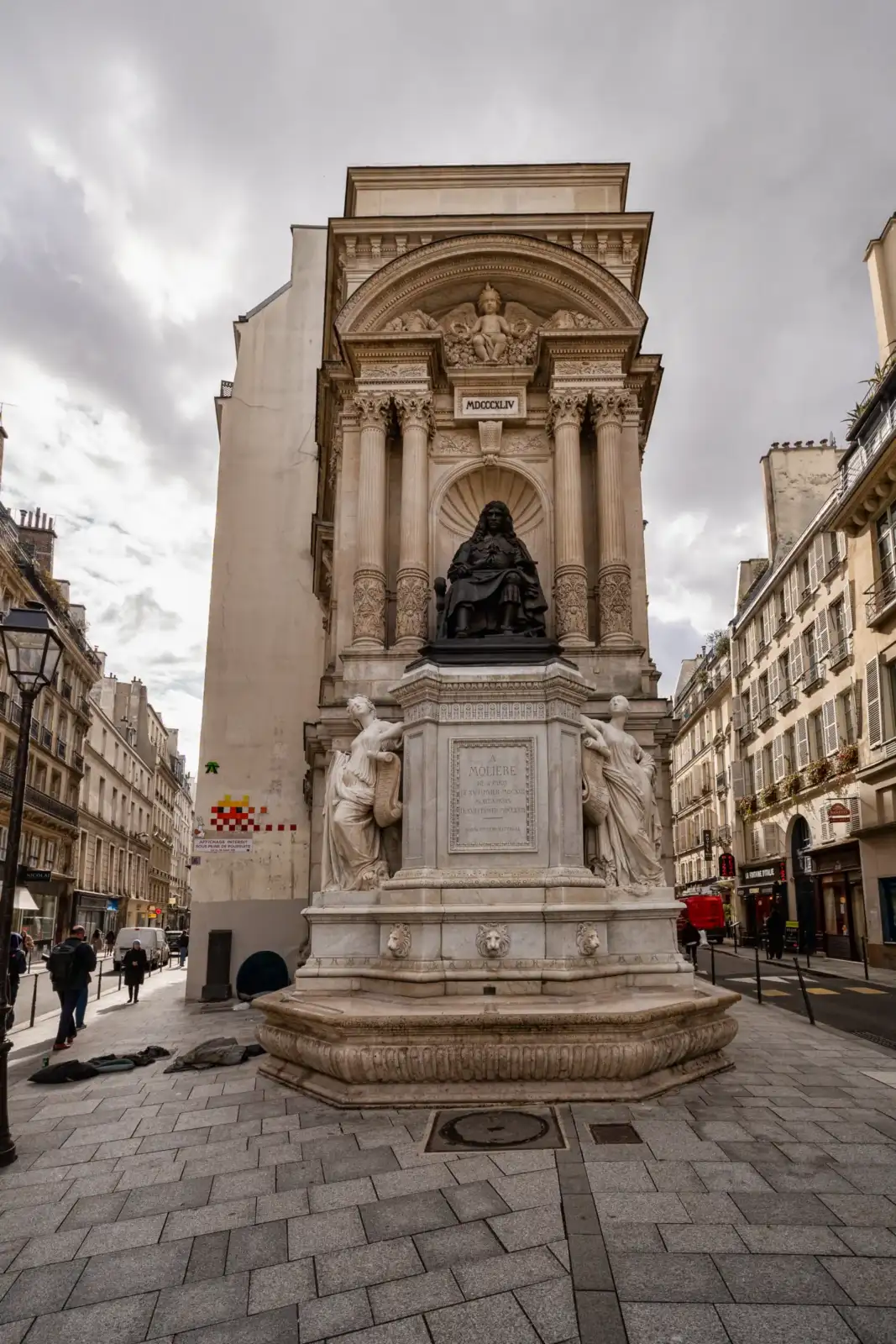 La fontaine Molière est une imposante structure sculptée située dans une rue de Paris.