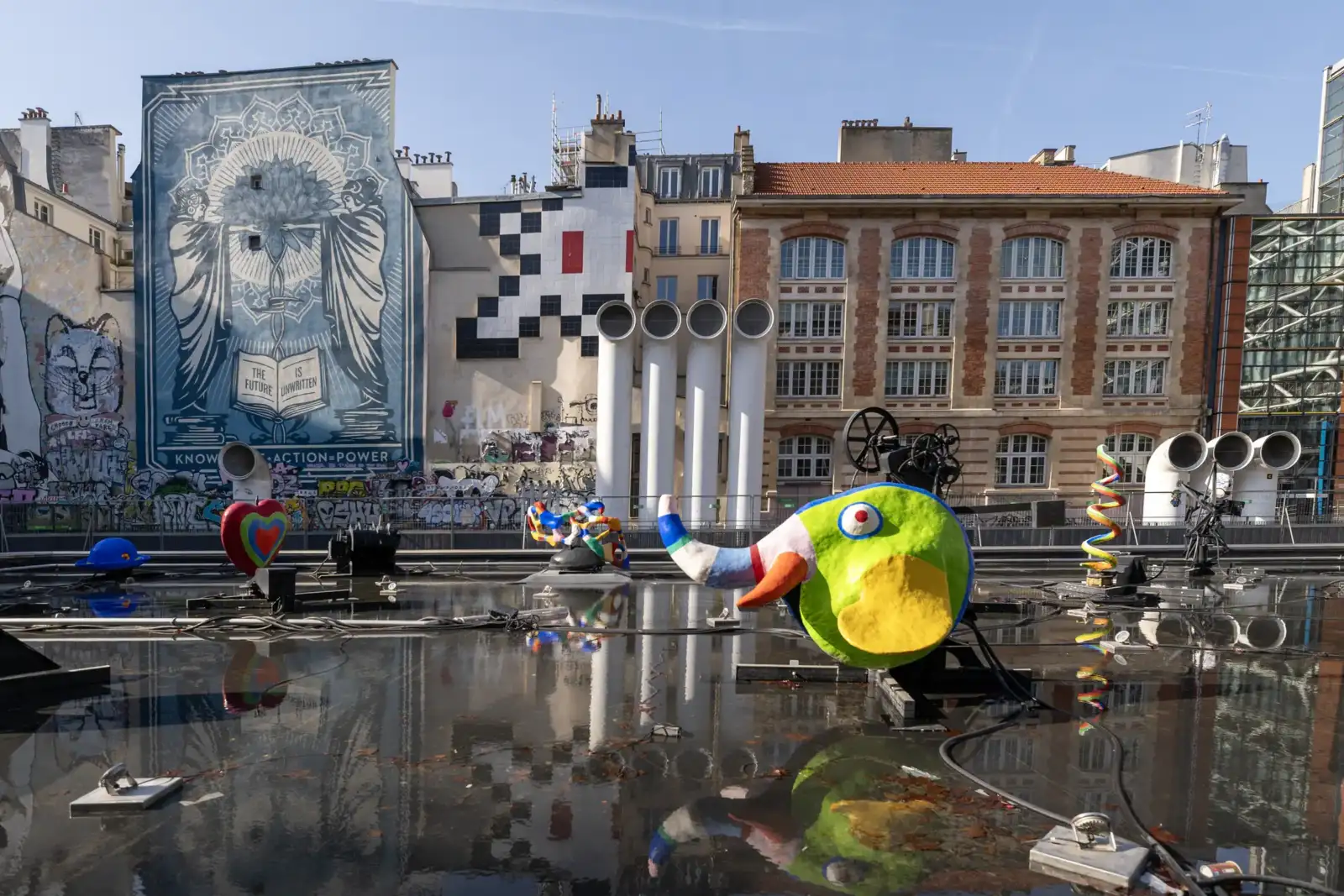 Des sculptures colorées et ludiques se reflètent dans le bassin de la fontaine Stravinsky parisienne.