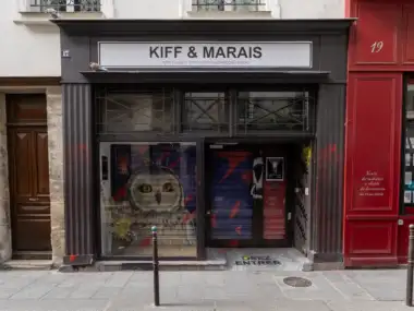 La devanture sombre de la galerie Kiff et Marais arbore une grande enseigne blanche.