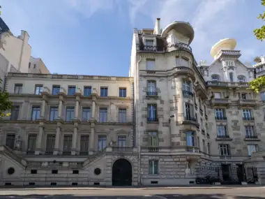 Façade élégante en pierre d un bâtiment haussmannien parisien sous un ciel bleu.