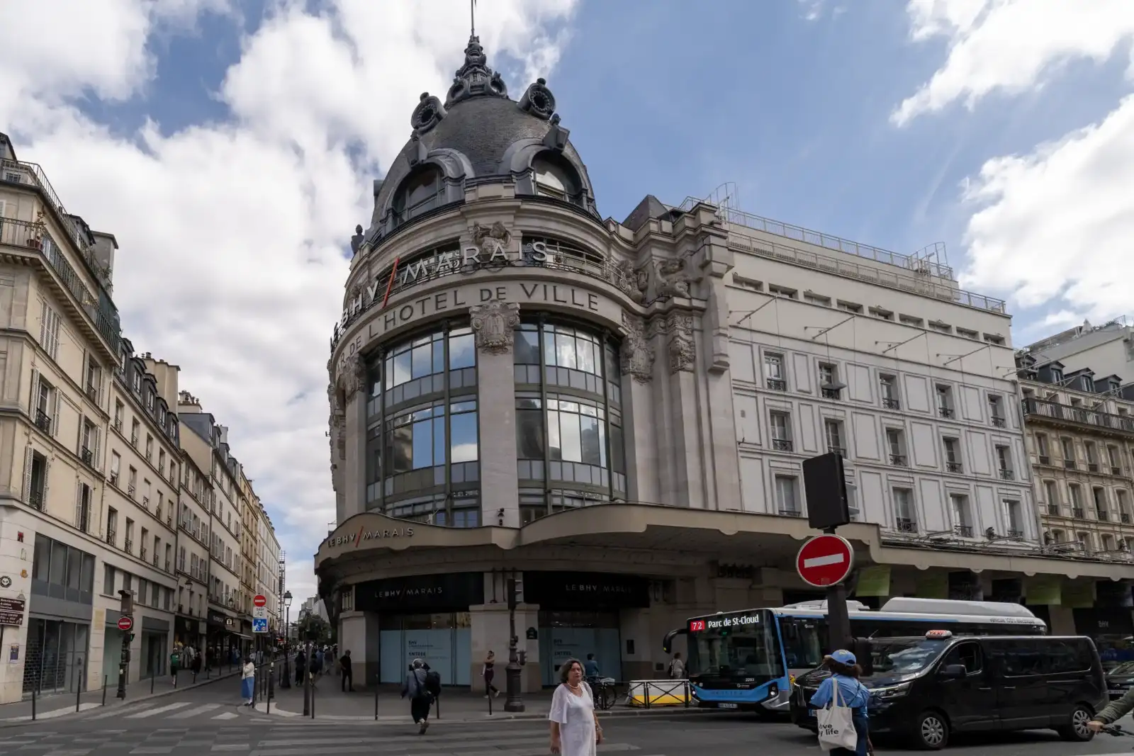 Vue de la façade principale du BHV Marais avec son dôme sous un ciel nuageux.