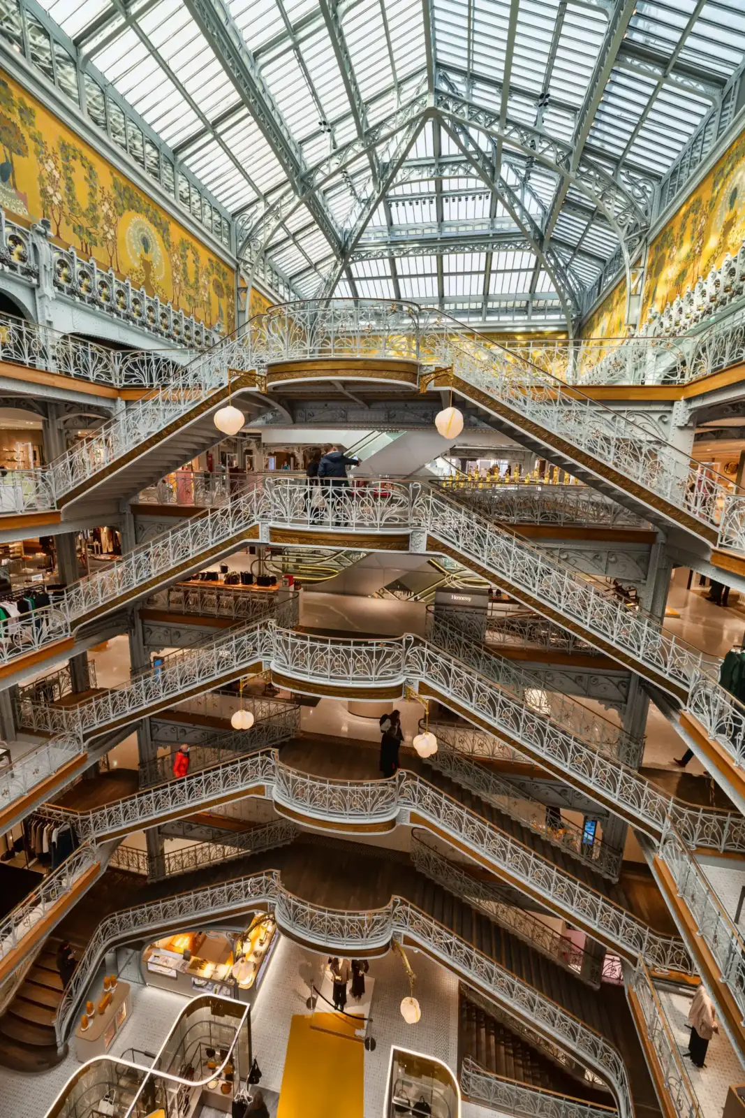 L'intérieur majestueux de la Samaritaine avec son grand escalier monumental sous une verrière lumineuse.