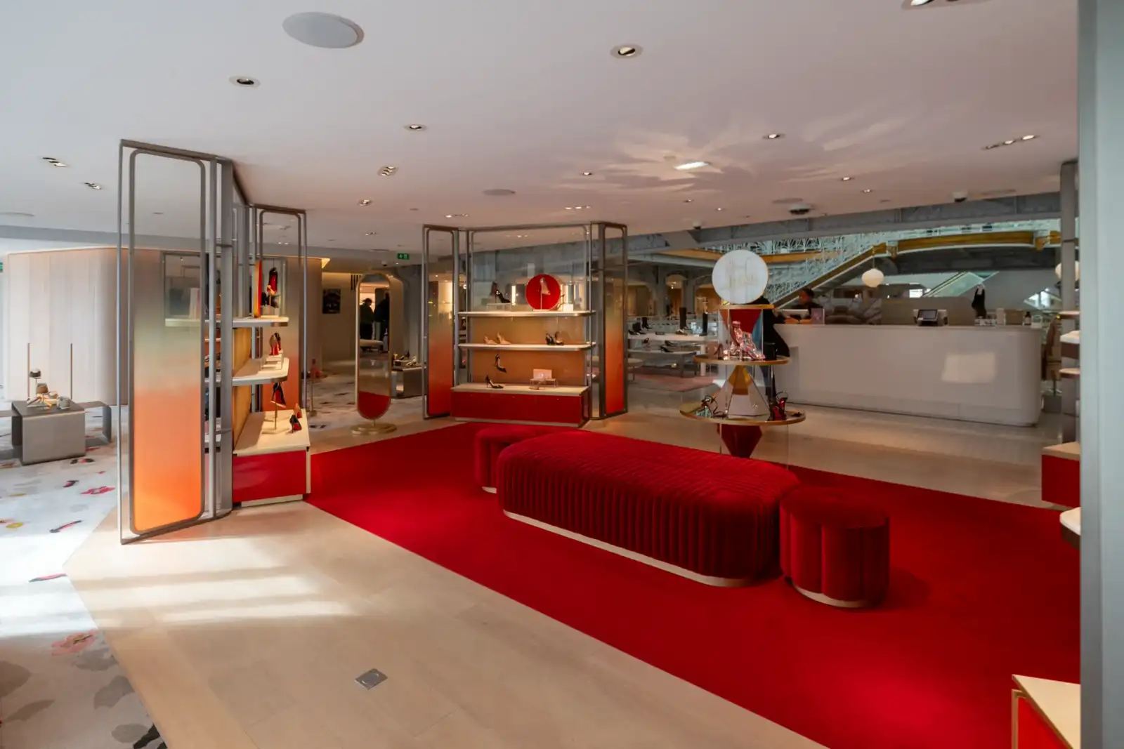 Un tapis rouge élégant décore l'espace luxueux de chaussures au grand magasin la Samaritaine.