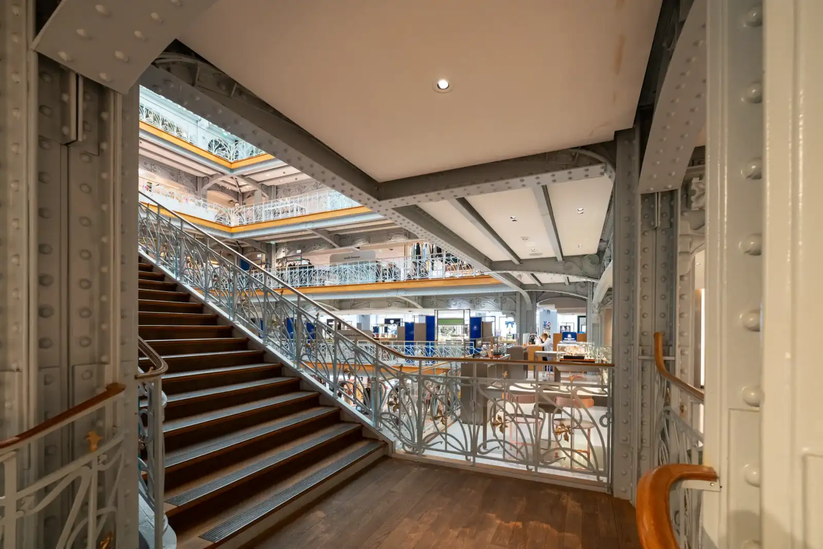 Vue intérieure élégante avec escalier en bois et structures métalliques du grand magasin la Samaritaine.