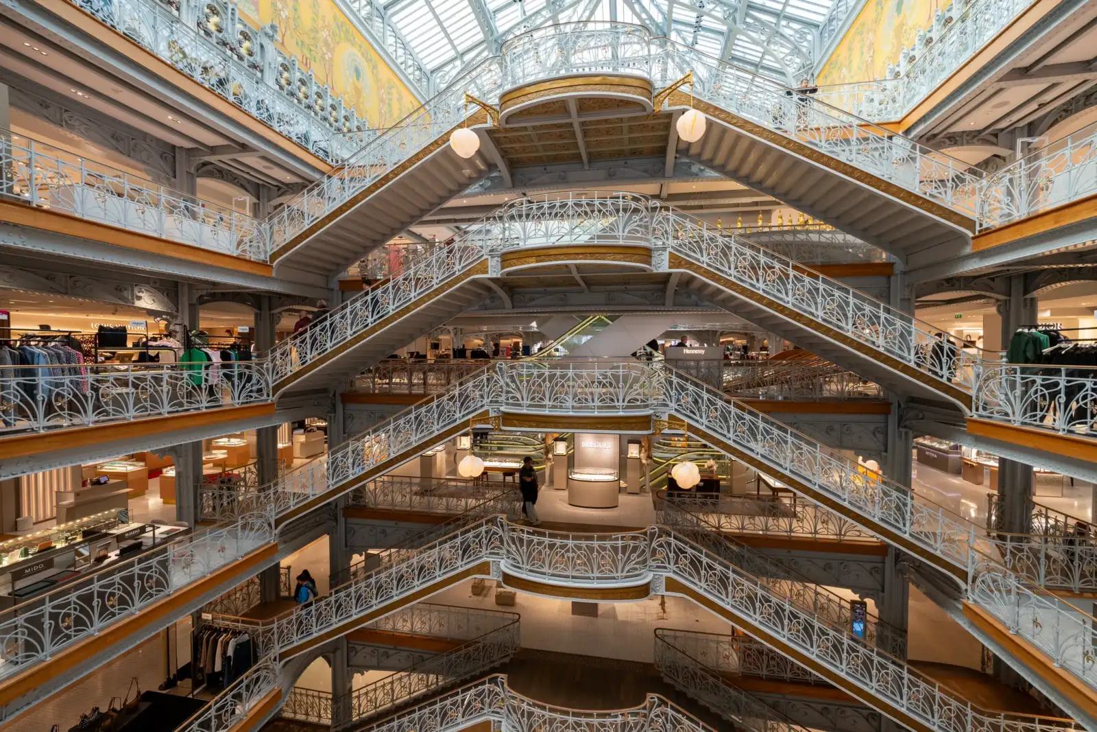 Vue intérieure majestueuse du grand magasin La Samaritaine avec ses escaliers monumentaux en fer.