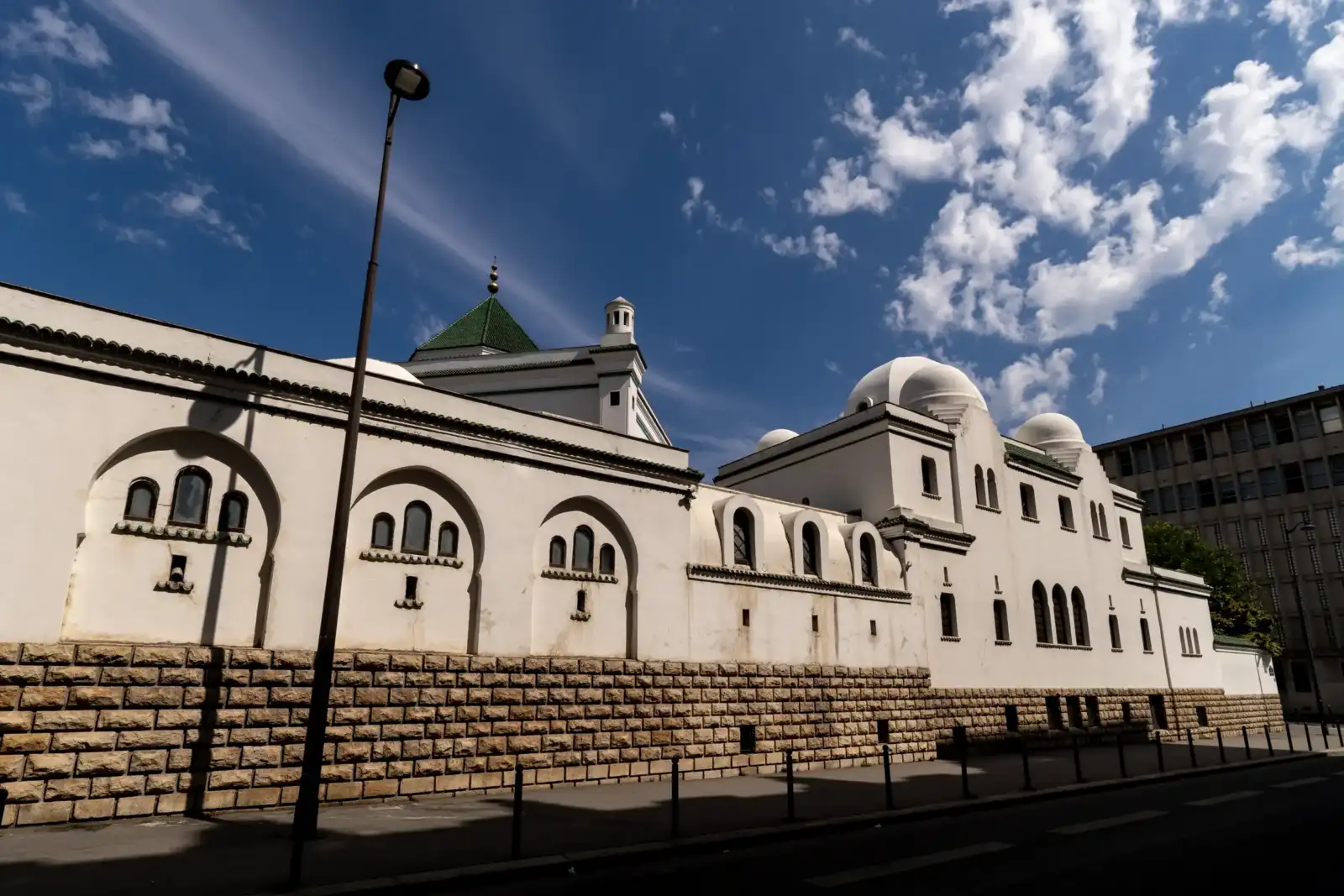 Façade blanche de la grande mosquée de Paris sous un beau ciel bleu.