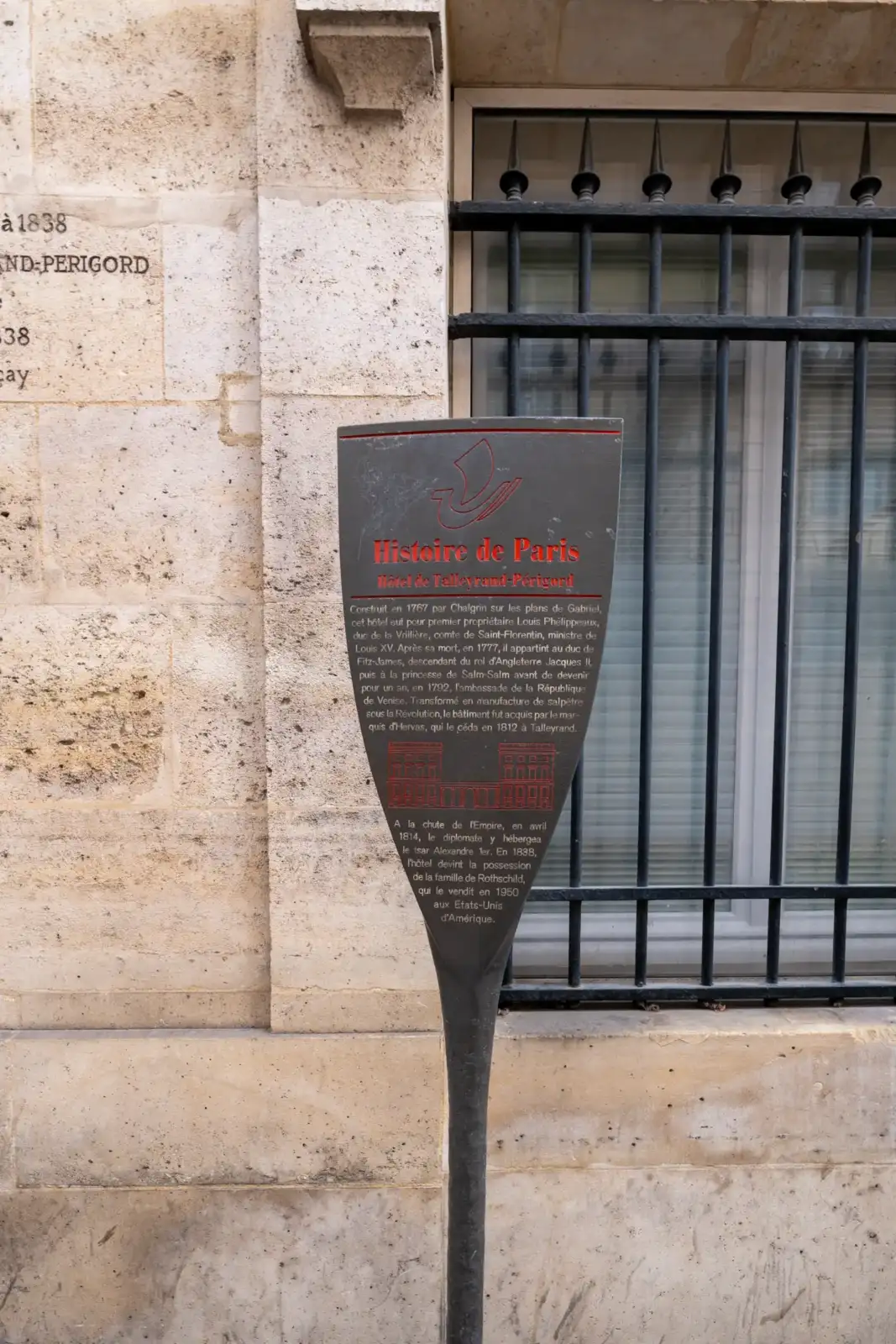 Panneau informatif Histoire de Paris devant la façade en pierre de l'hôtel Talleyrand.