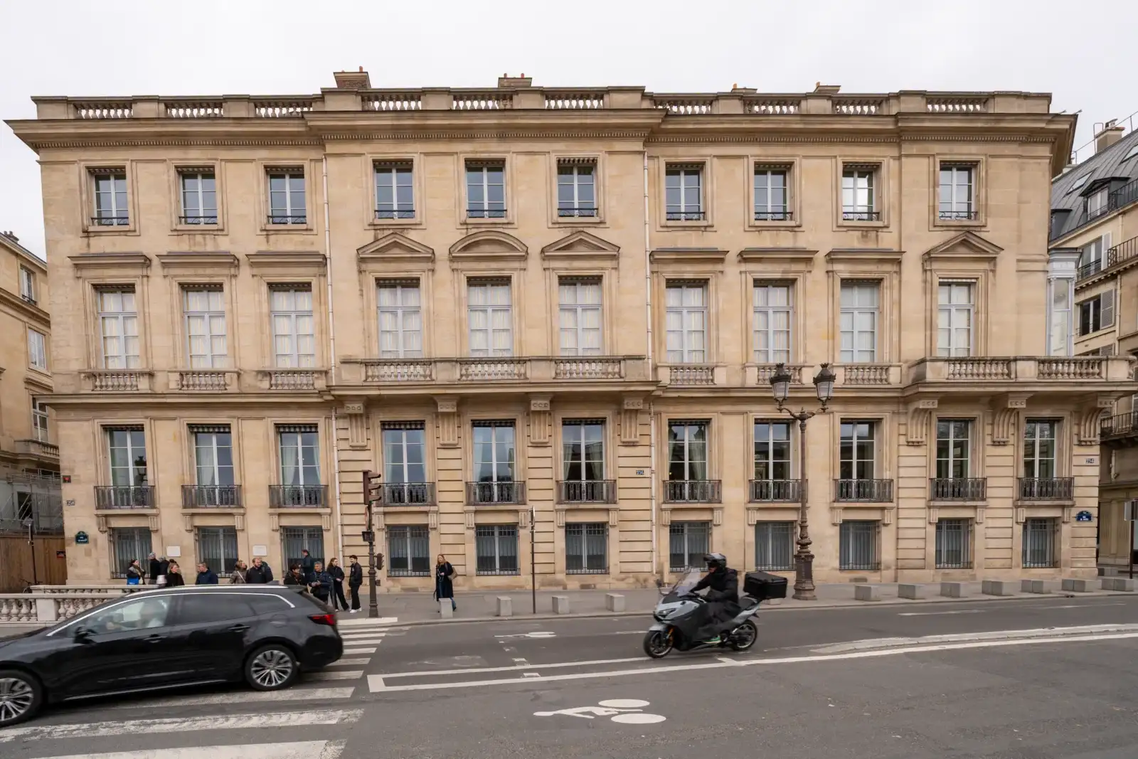 La façade classique de l'hôtel Talleyrand à Paris surplombe une rue animée avec circulation.