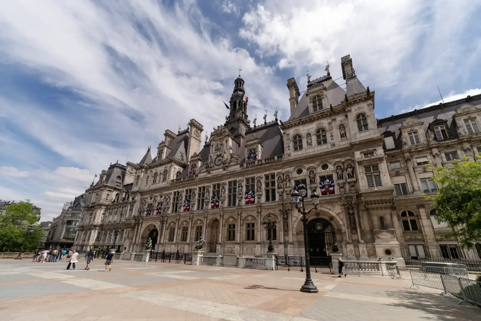 La vaste façade sculptée de l'Hôtel de Ville de Paris sous un ciel nuageux.