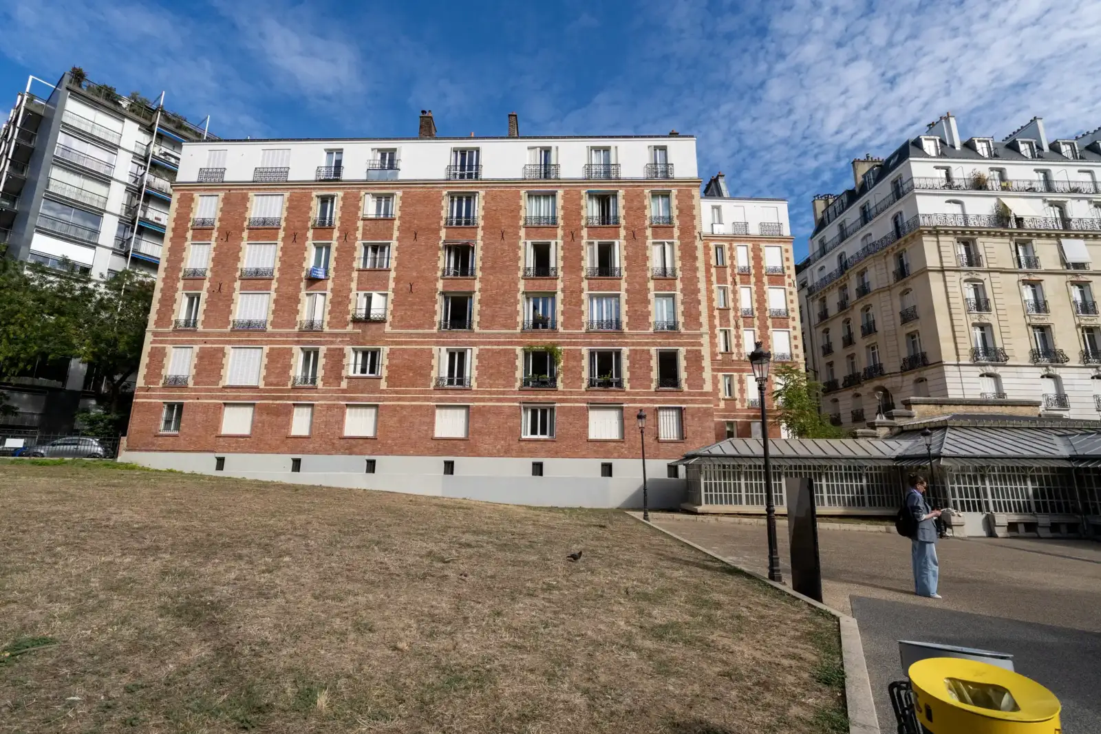 Vue de face d un immeuble extra plat en briques rouges a Paris.
