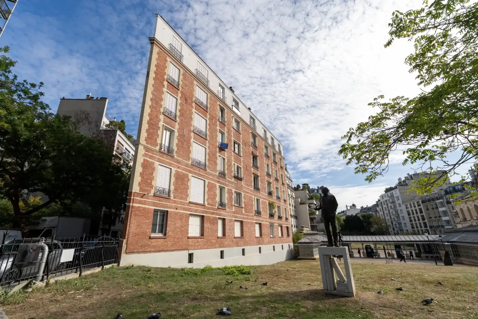 Vue en contre-plongée d un immeuble parisien particulièrement étroit, avec une statue au premier plan.