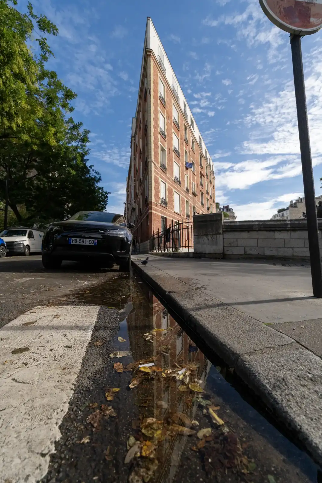 Vue en contre-plongée d un immeuble parisien très fin, avec sa façade en briques rouges.
