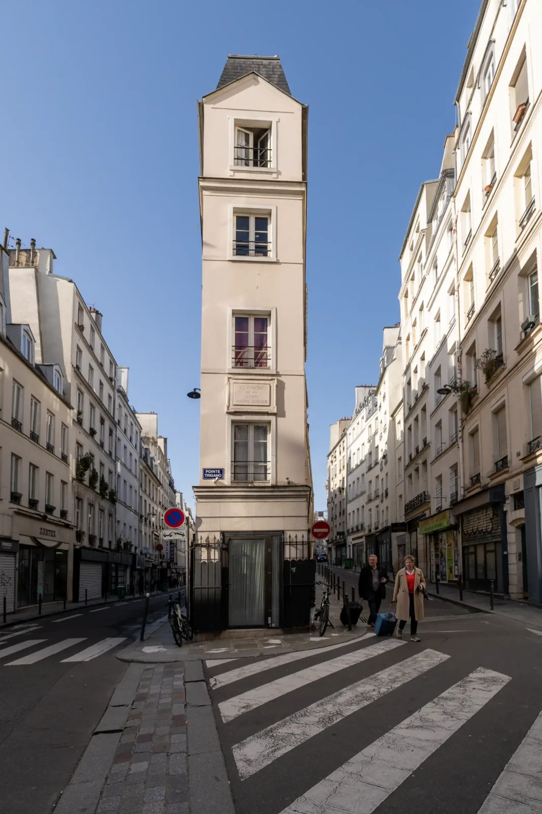 Un immeuble très étroit se dresse à une intersection ensoleillée dans le deuxième arrondissement parisien.