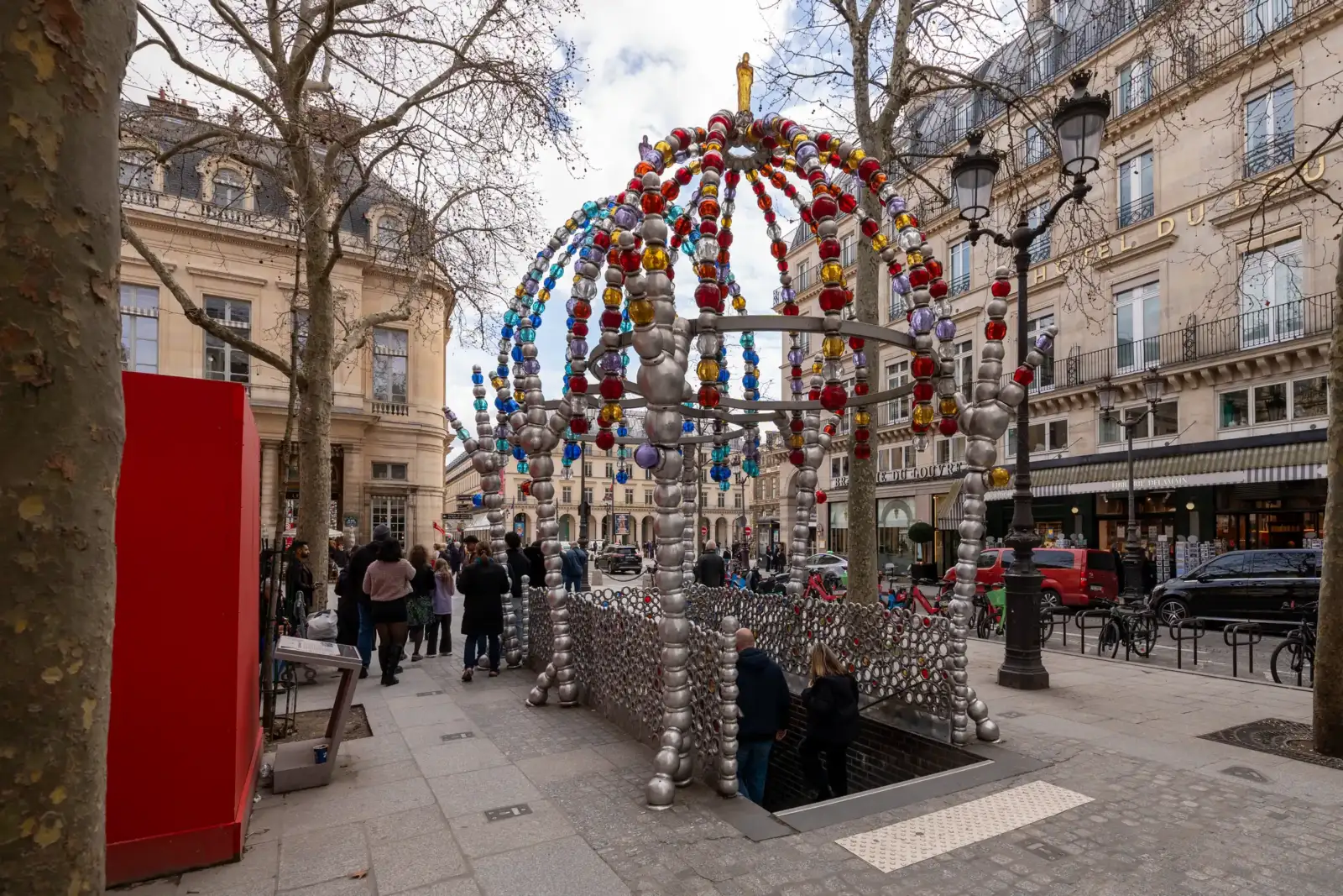 Une structure métallique ornée de boules colorées surplombe l'entrée du métro parisien Palais-Royal.
