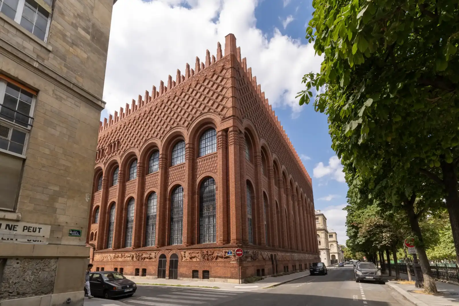Vue en contre-plongée de la façade en briques rouges de l'institut d'art et d'archéologie à Paris.
