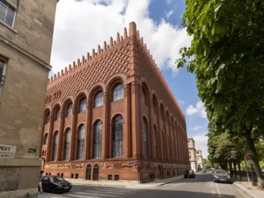 Vue en contre-plongée de la façade en briques rouges de l'institut d'art et d'archéologie à Paris.