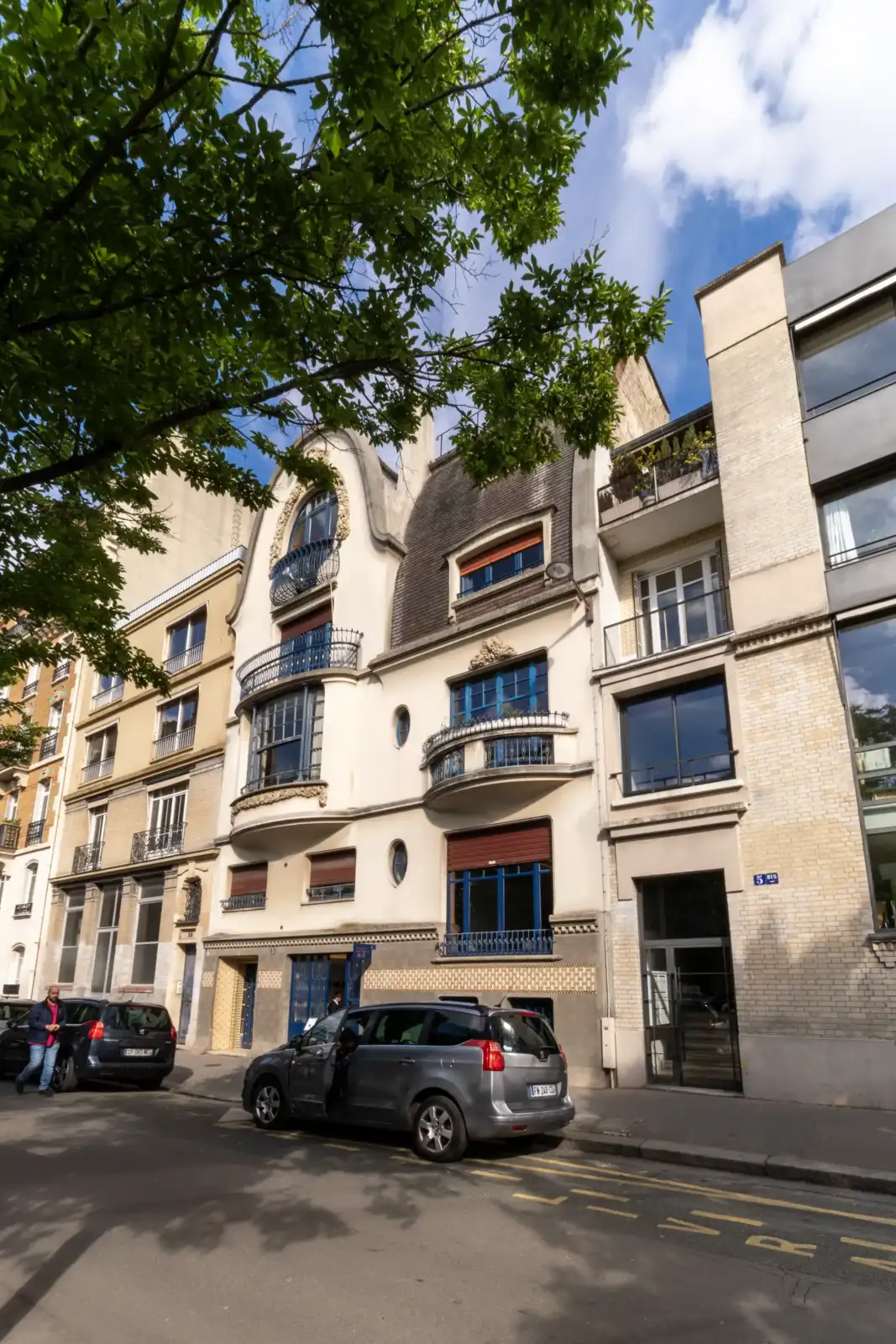 Façade sculptée de l'Institut Giacometti à Paris sous un feuillage vert.