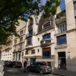 Une rue parisienne ombragée montre la façade élégante et ancienne de l institut Giacometti.