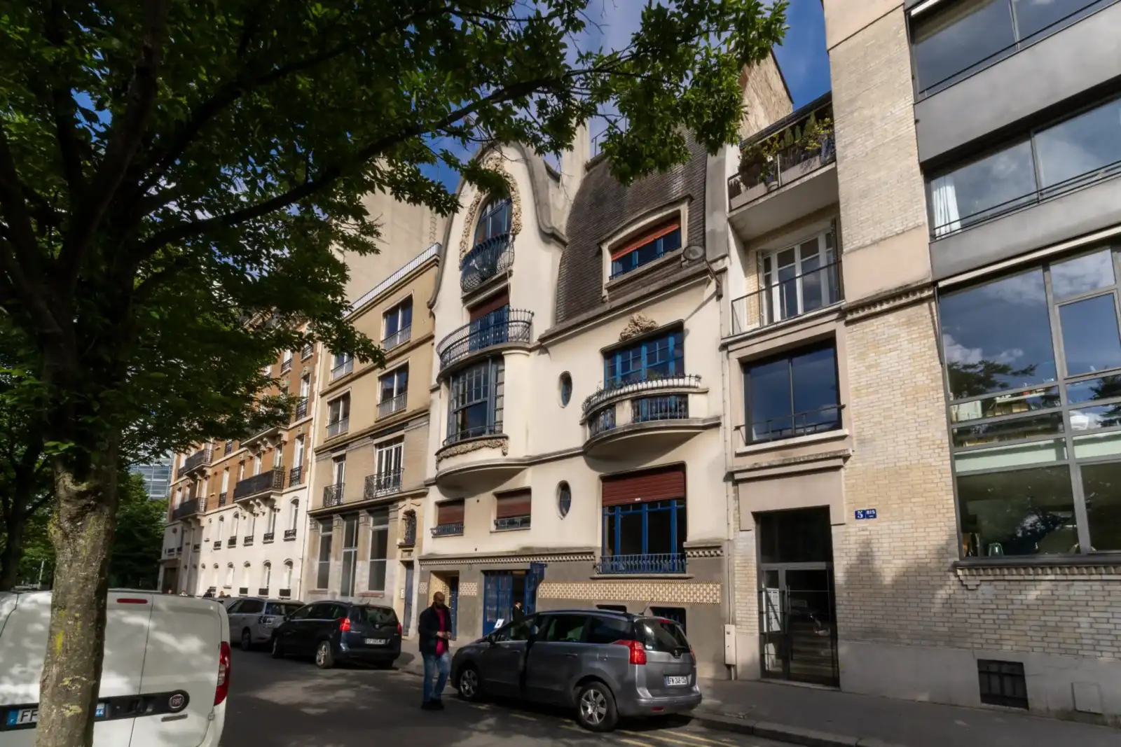 Une rue parisienne ombragée montre la façade élégante et ancienne de l institut Giacometti.
