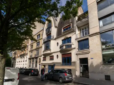 Une rue parisienne ombragée montre la façade élégante et ancienne de l institut Giacometti.