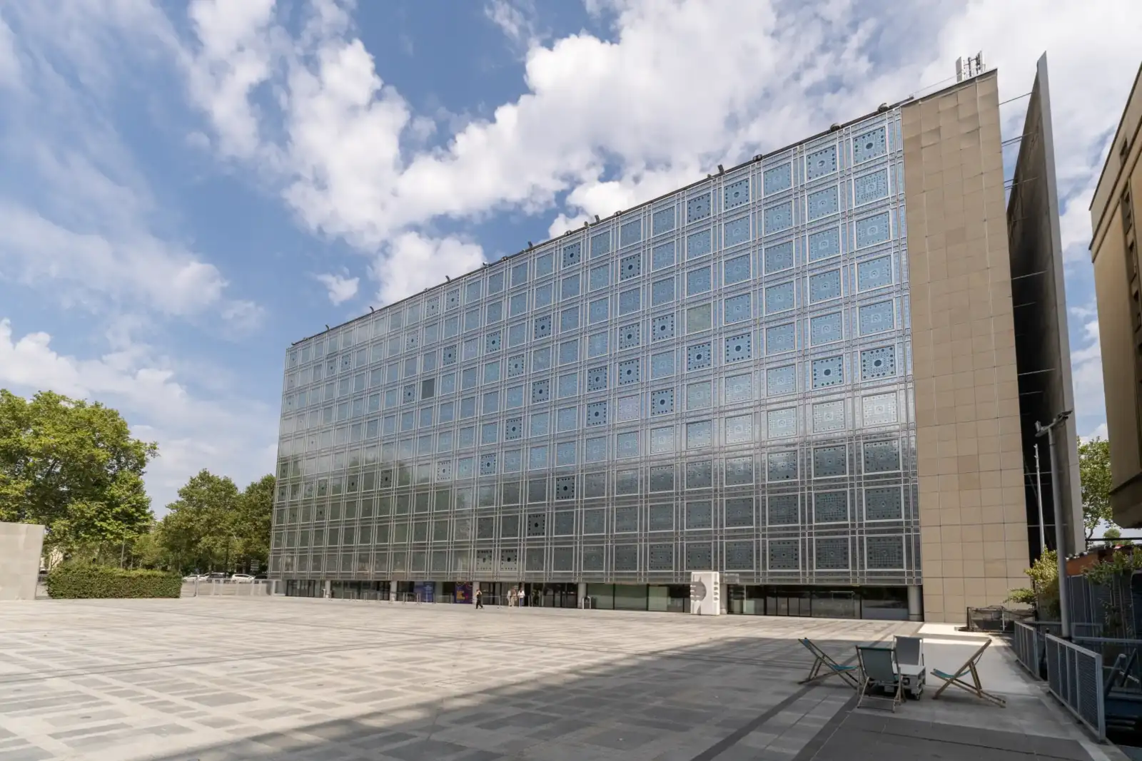 Vue de la façade vitrée de l institut du monde arabe sous un ciel nuageux