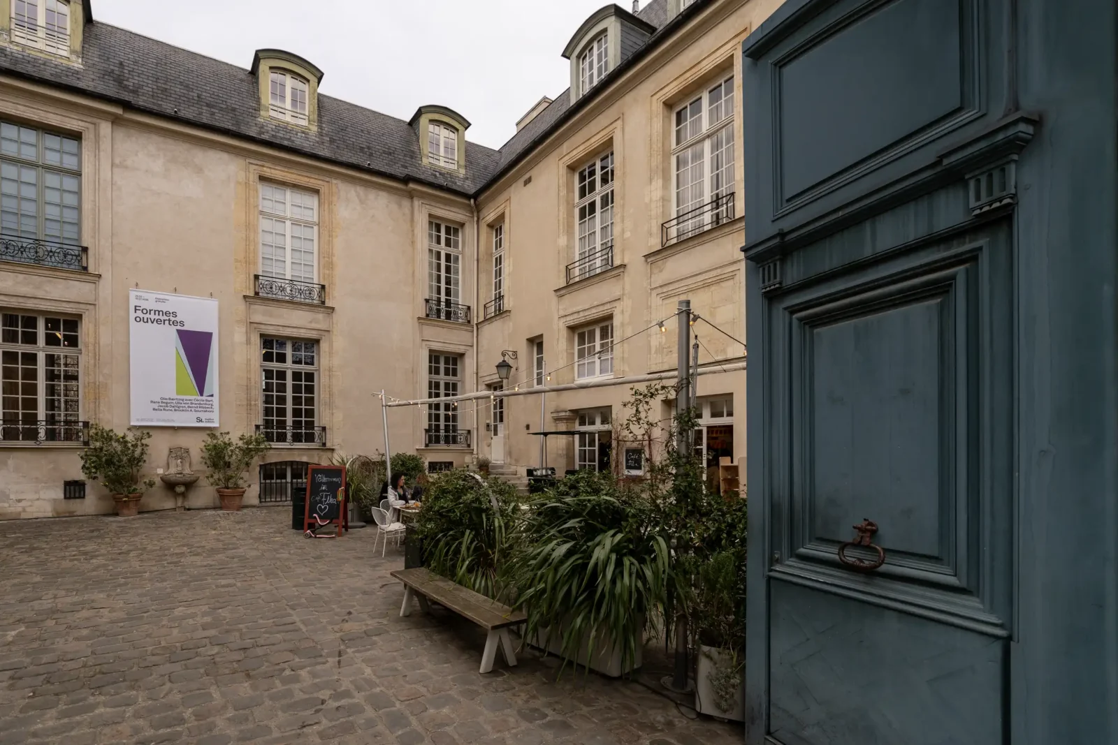 La cour pavée de l'Institut suédois à Paris présente une façade classique et verdoyante.
