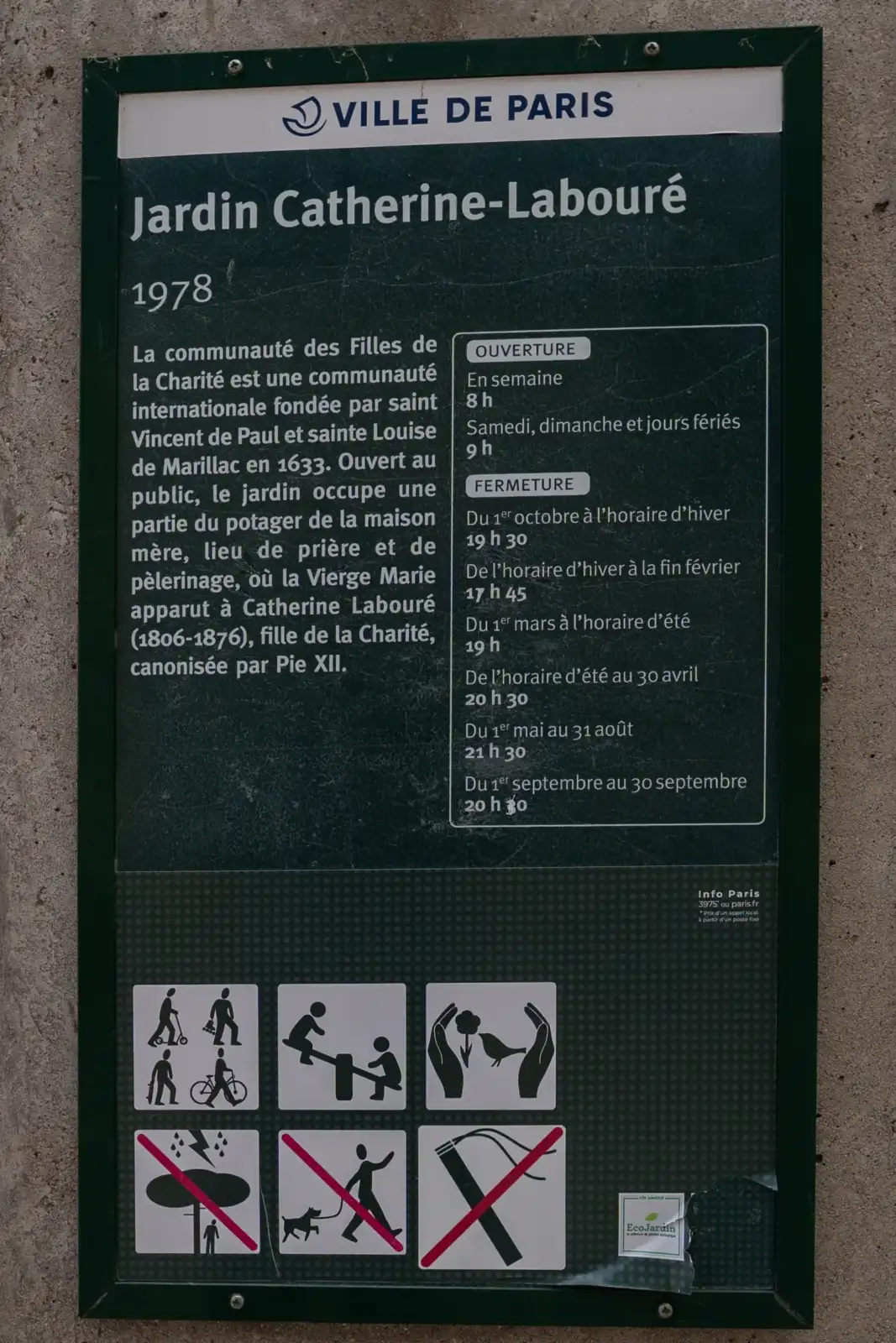 Un panneau d information vert de la Ville de Paris affiche l historique et les horaires du jardin Catherine Labouré