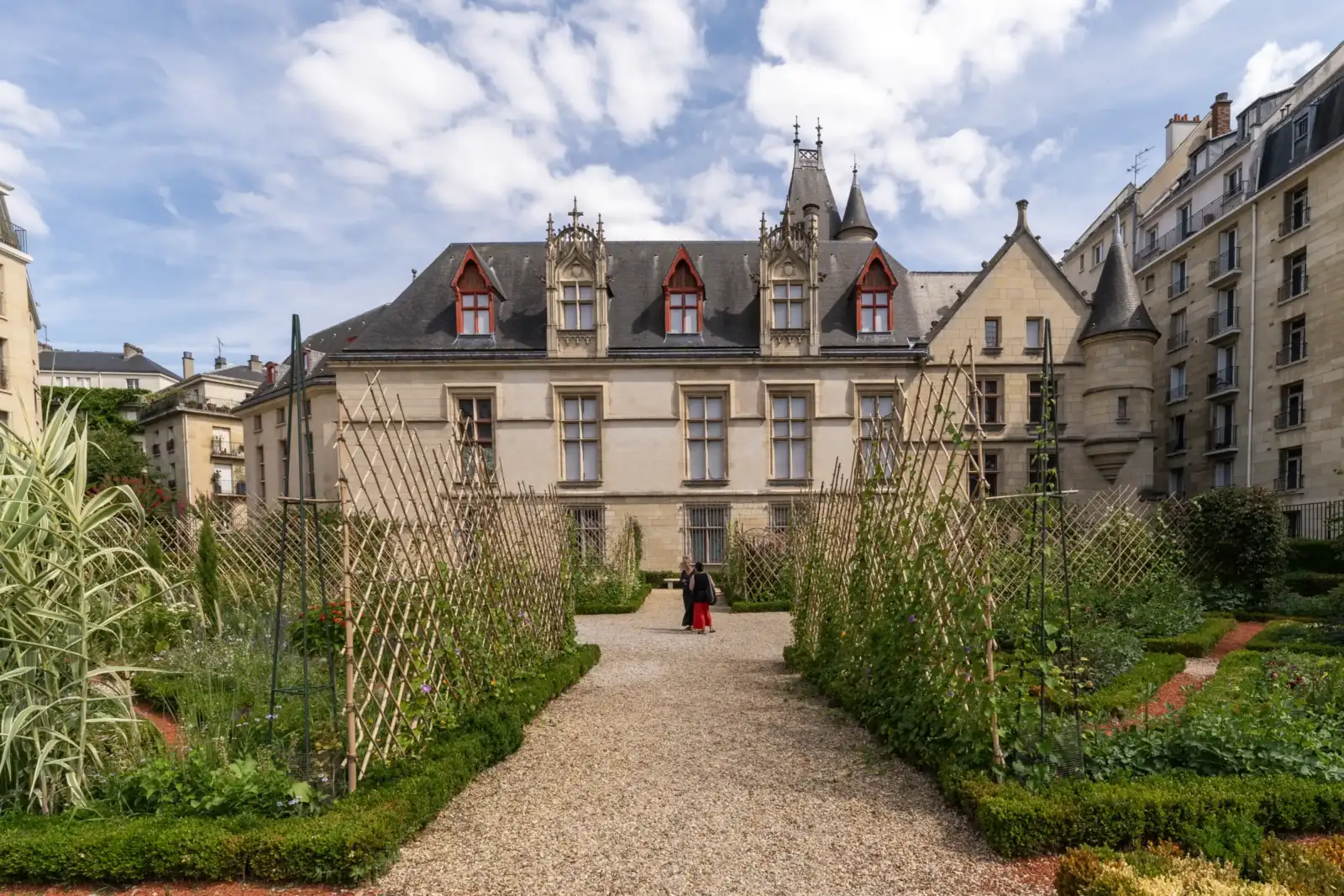 Une vue frontale du jardin fleuri de l'hôtel de Sens à Paris.