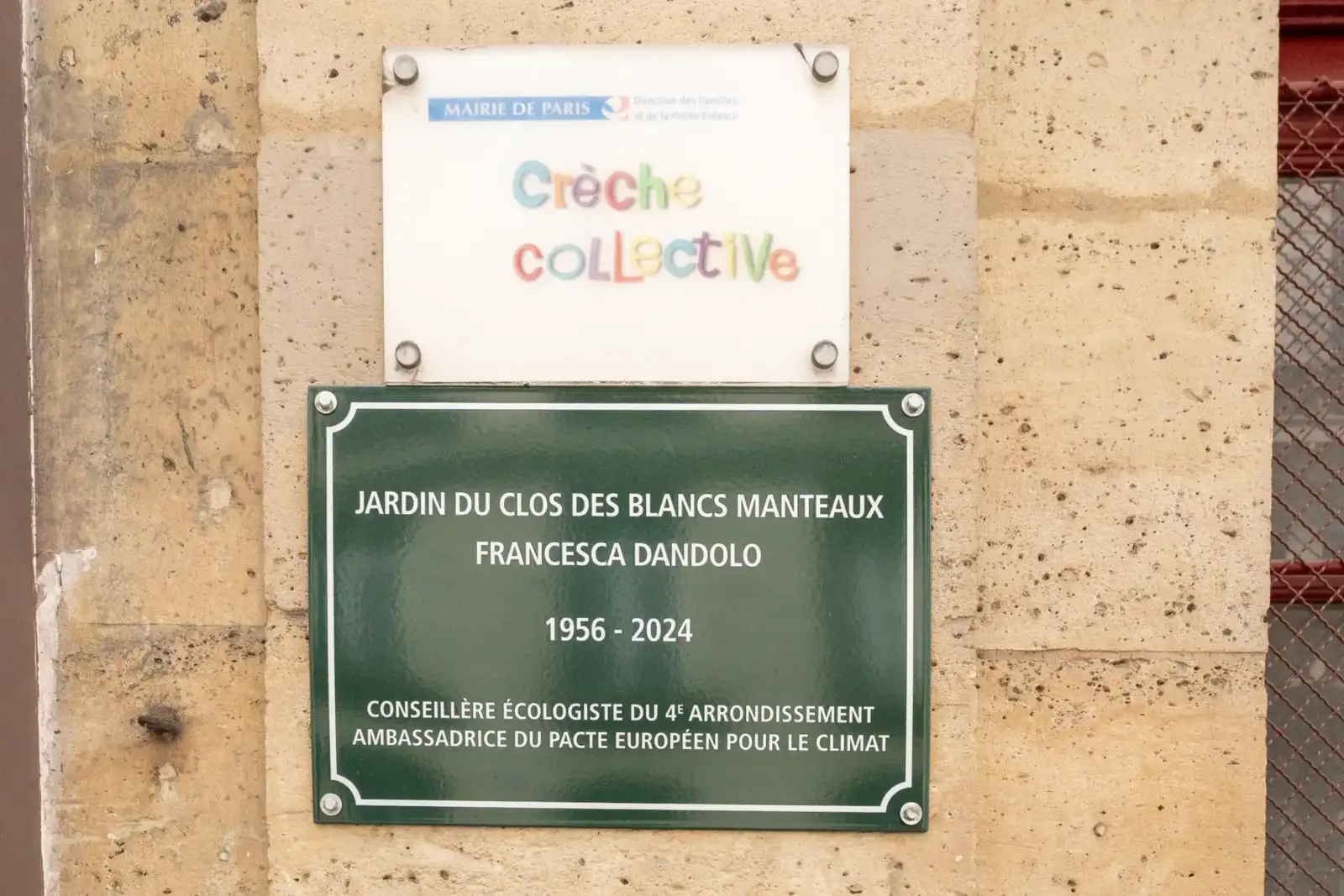 Deux plaques signalétiques fixées sur un mur en pierre beige, indiquant un jardin parisien.