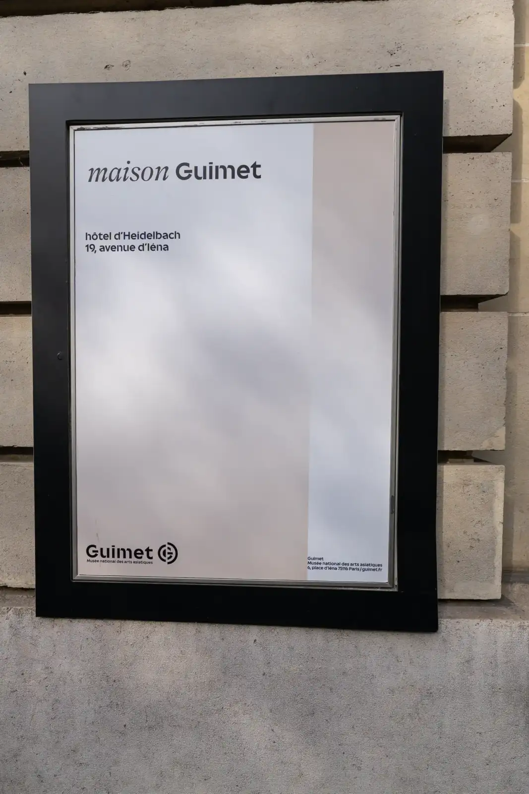 Un panneau noir et blanc affiche le nom de la maison Guimet sur un mur.