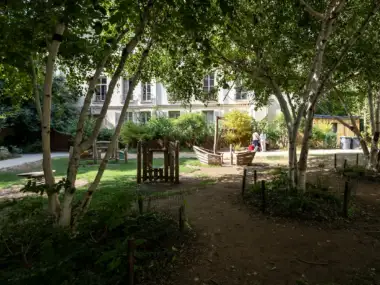 Des bouleaux ombragent une aire de jeux pour enfants dans ce jardin parisien.