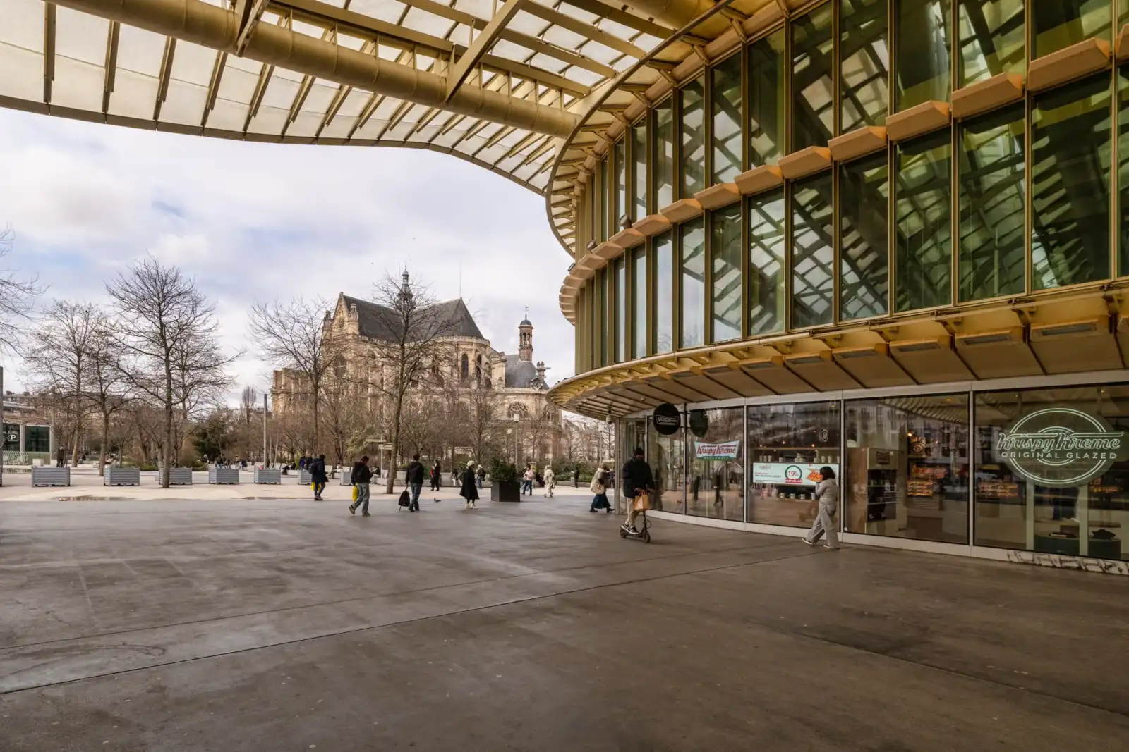 La façade moderne de la Canopée des Halles avec l'église Saint-Eustache en arrière-plan.