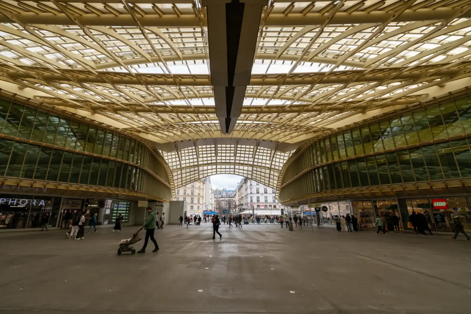 Vue grand angle de la Canopée des Halles à Paris avec des passants flânant.