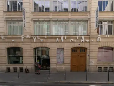 Façade en pierre claire de Lafayette Anticipations à Paris, avec signalétique et visiteurs.