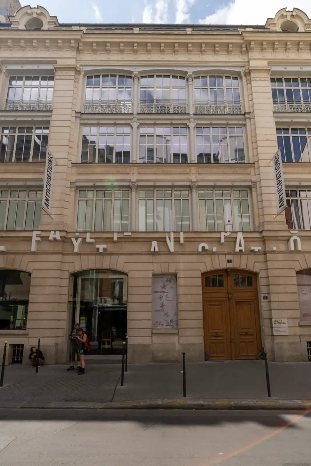 Vue en contre-plongée de la façade classique de Lafayette Anticipations à Paris sous un ciel nuageux.