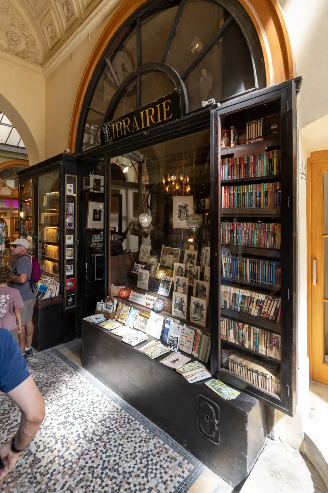 Devanture ancienne de la librairie Jousseaume avec des vitrines remplies de livres et cartes postales.